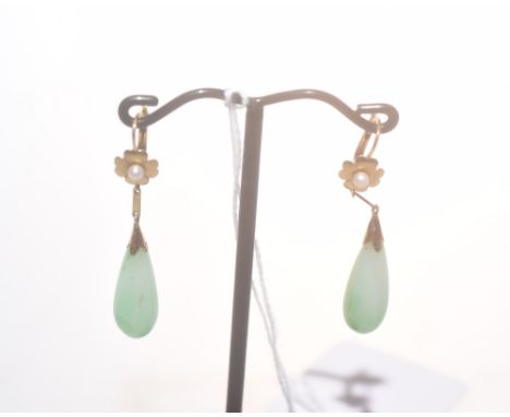 A pair of gold mounted jade drop earrings, the flower head mounts (unmarked but test as gold) each centred by a small pearl.