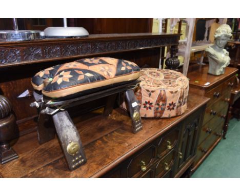 A vintage camel saddle; tog. with a pouffe