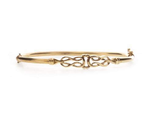 NINE CARAT GOLD BANGLE of oval form, with central pierced knotwork section, 67mm to outer edge, 8.1g