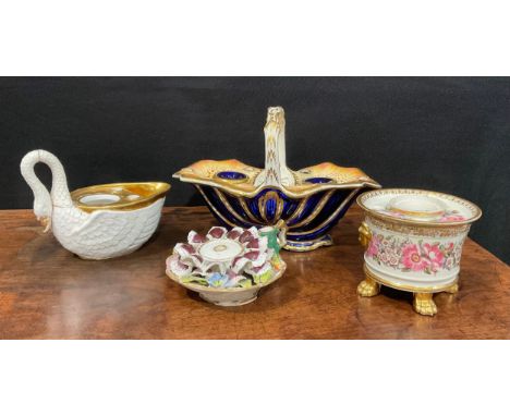 An English porcelain inkstand in the shape of a basket of naturalistic form, with two removable inkwells and six pen holders,