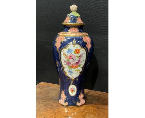 A Royal Worcester baluster vase and cover, by Ernest Phillips, painted with panels of flowers on a blue scale ground, with fu