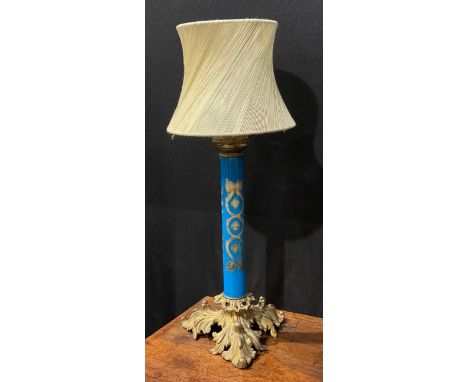 An early 20th century gilt metal and blue glass table lamp, the cylindrical pillar decorated in gilt with leafy strapwork, th