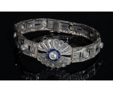 An Art Deco diamond and sapphire panel bracelet in the manner of Cartier, each panel centered with an round cut diamond withi