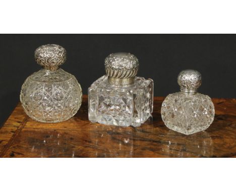 A large Victorian silver mounted glass inkwell, the hinged domed cover chased with flowers and scrolling foliage, enclosing a