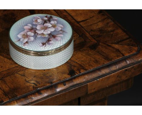 A Continental silver and enamel circular snuff box, hinged cover decorated with a blossoming branch, on a pale blue guilloche