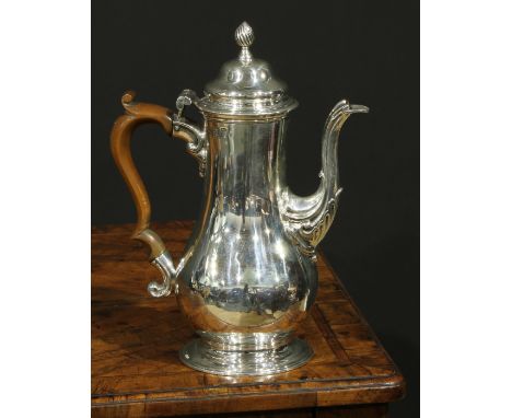 An early George III silver baluster pedestal coffee pot, hinged domed cover with spiral knop finial, fruitwood scroll-capped 