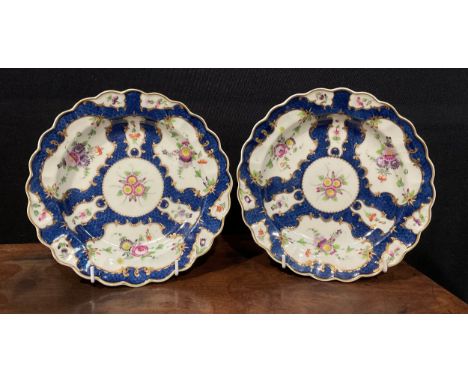 A pair of Worcester shaped circular plates, decorated with alternating fan and vase shaped reserves, each with summer flowers