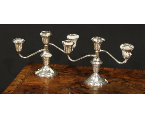 A pair of American silver three-light table candelabra, bell shaped sconces, circular bases, 24.5cm wide, marked Sterling, c.