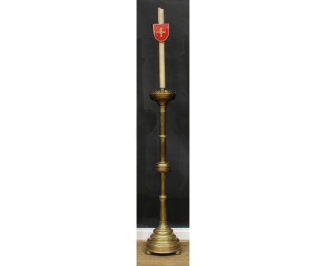 Ecclesiastical Salvage - a brass floor-standing chancel candlestick, the upper sconce applied with a shield centred by a cros