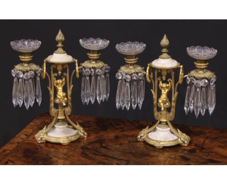A pair of 19th century French gilt metal and alabaster two-light mantel candle lustres, each centred by a scantily clad putto