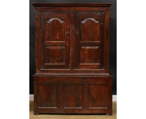 An early 18th century oak housekeeper’s livery or provision cupboard, inscribed HP and IR, moulded cornice above a pair of ra