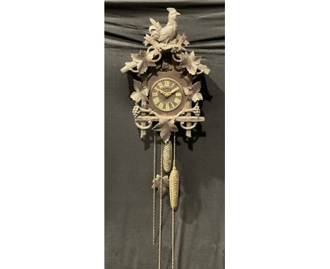 A Black Forest cuckoo clock, 13cm dial applied with Roman numerals, the case crested by a cockerel and bordered with fruiting