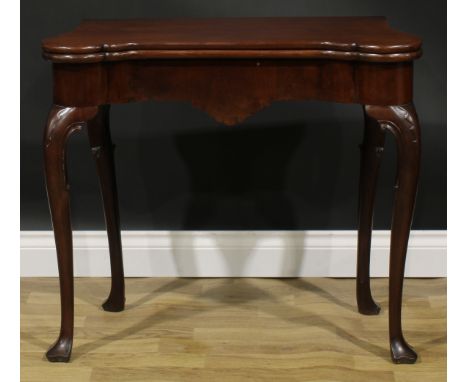 A George II Irish mahogany card table, hipped rectangular folding top enclosing a baize lined playing surface and counter wel