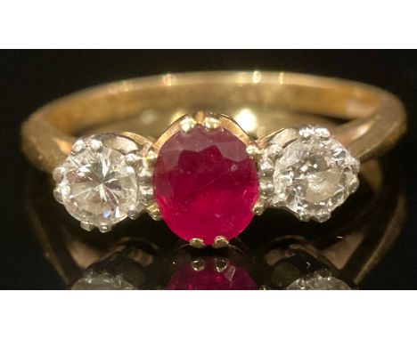 A diamond, rub and 18ct gold three stone ring, the central ruby flanked by a pair of round brilliant cut diamonds, claw set, 