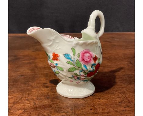 A Worcester dolphin ewer cream jug, in relief with shell moulding, painted in polychrome with flowers and sprigs, lamprey eel