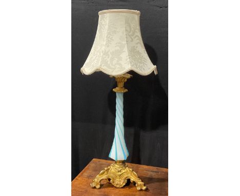 An early 20th century gilt metal and Bohemian glass table lamp, wrythen pillar, the triform base cast with leafy scrolls, 48c