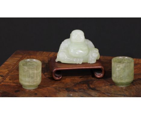 A Chinese jade carving, of Budai, he sits, rotund, holding beads, 10cm wide, hardwood stand; a pair of cylindrical wine cups,