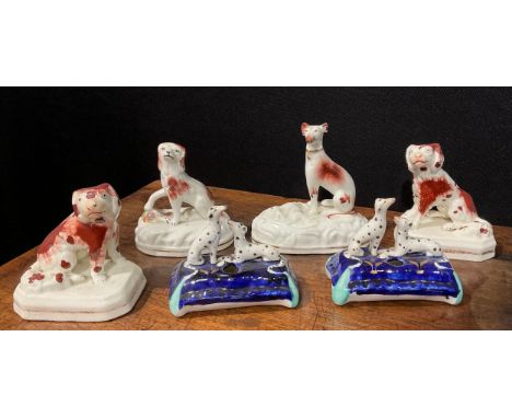 A pair of Staffordshire Spaniels, seated to the left and right, picked out in rust brown, gilt lined canted rectangular bases