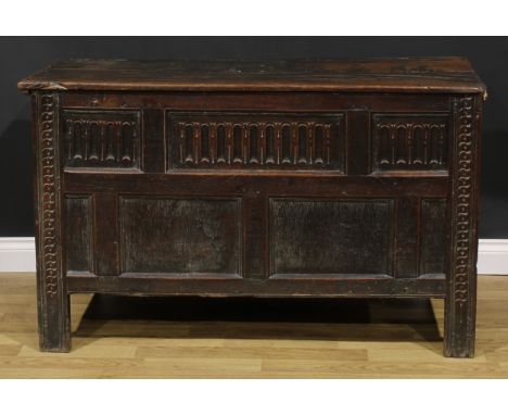 A late 17th century oak blanket chest, hinged top above a nulled panel front, the stiles carved with stylised S-motifs, 79cm 