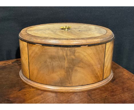 A late 19th century oval mahogany box and cover, crossbanded and outlined with ebony stringing, moulded borders, cast foliate