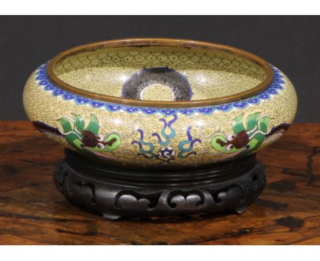 A Chinese cloisonne enamel circular bowl, decorated in polychrome with a ferocious dragon, 17cm diam, hardwood stand 