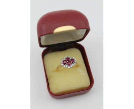 AN 18CT GOLD LADY'S RUBY &amp; DIAMOND CLUSTER RING, the centre set four rubies, surrounded by sixteen brilliant cut diamonds