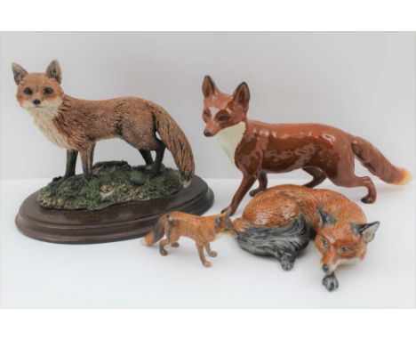 A BESWICK POTTERY STANDING FOX, factory marks to base, 13cm high together with; an 'Excalibur' pottery fox, a small ceramic f