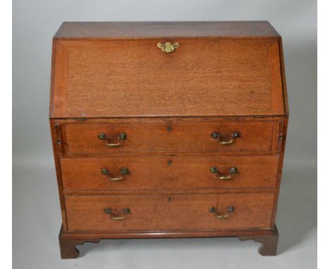 A GEORGE III OAK FALL FRONT WRITING BUREAU, over three long drawers with brass handles, on bracket feet, 99cm wide 