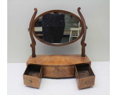 A 19TH CENTURY MAHOGANY BOW FRONT DRESSING TABLE MIRROR, having oval framed plate over three drawers to base, on bracket feet