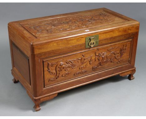 A Chinese carved camphor wood trunk with carved dragon design to the hinged lift-lid &amp; front, &amp; on bracket feet, 39½”