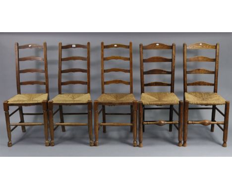 A matched set of five ladder-back dining chairs with woven rush seats, &amp; on turned legs with spindle stretchers.