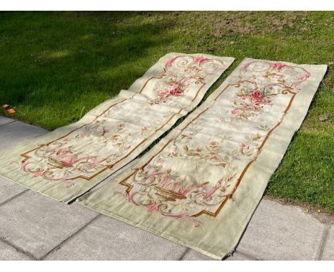 A pair of Aubusson tapestry portière, mid 19th Century, each with a cream field and central flower spray within a scrolling s