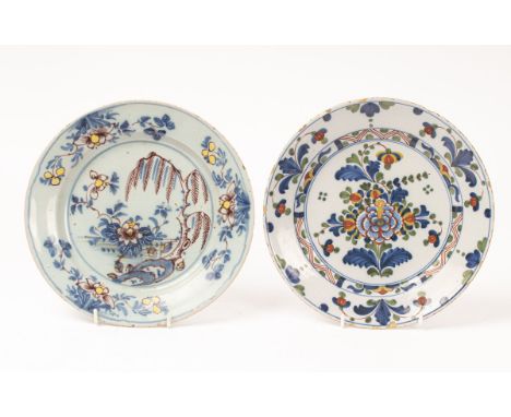 An English polychrome Delftware plate, in blue, manganese and yellow with a willow and flowers, Lambeth or Bristol and anothe