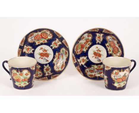 A pair of Worcester blue scale ground Kakiemon pattern cups and saucers, circa 1760, of tapering form with mirror-shaped cart