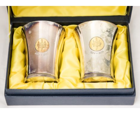 A pair of silver beakers, trumpet form with fluted banding to the feet, gilded crest and 1884-1984, London 1984, 10cm high, 1