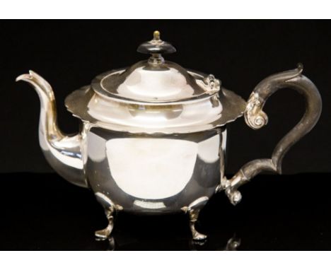 An Edwardian silver teapot, of cup bell form on four trefoil pad feet, ebonised ear handle Thomas Hayes, Birmingham 1905, 16c