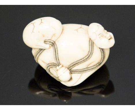 An oriental ivory netsuke, in the form of two shells and a mask, signed, width 4.5cm