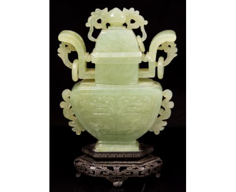 A Chinese carved jade vase of Koro form, the body decorated to each side with zoomorphic foliate panels, ring handles and dra