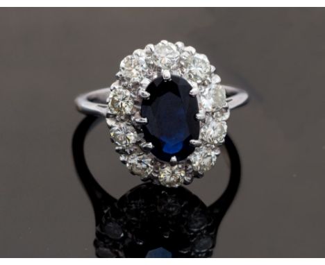 A sapphire and diamond cluster ring, centre oval mixed cut sapphire approximately 10 x 6mm, surround set with ten round brill