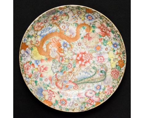 A Chinese kangxi circular dished bowl, extensively decoarted in the famille rose palette with a dragon amongst flowering foli