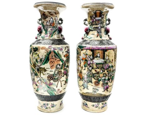 A pair of Chinese late Qing/early 20th Century twin handled baluster vases, carved and bronzed borders containing famille ros