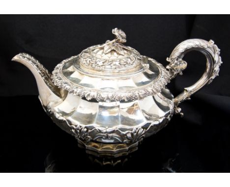 A George IV silver teapot, rose finial, vine border, the body of broad fluted bombe form, scroll handle, maker Rebecca Emes a