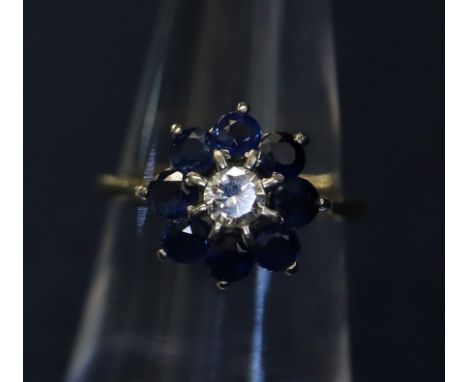 An 18ct gold sapphire and diamond cluster ring, central brilliant cut diamond surrounded by eight sapphires. Approx weight 4g