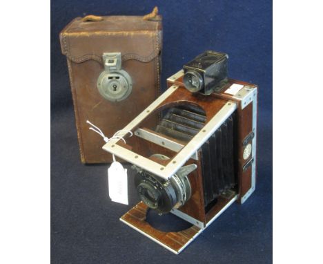 A Shew XIT patent mahogany folding plate camera with Lukos II lens and original leather carrying case with three dark slides.