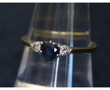 An 18ct gold sapphire and diamond ring, central heart shaped sapphire flanked on either side by a brilliant cut diamond. Appr