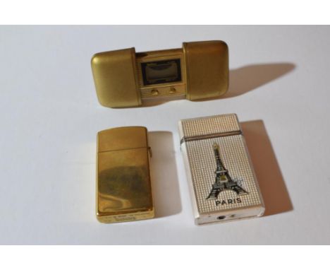 the brass lighter engraved with a Claddagh ring together with another souvenir lighter and a gilt cased digital travel clock