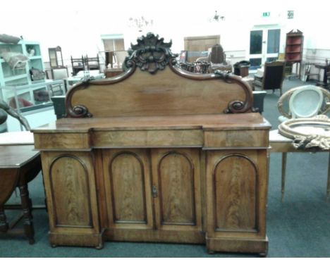 the carved panel back raised above a plain inverted breakfront top supported by frieze drawers above cupboards with moulded p