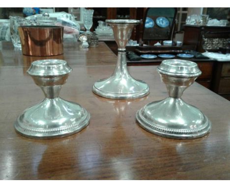 the pair of short candlesticks standing on circular bases with beaded decoration together with another silver desk candlestic