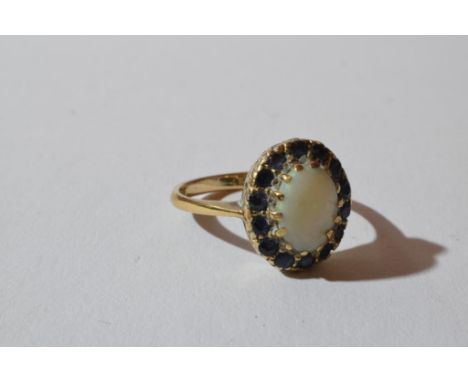 the central opal held by a ring of small round cut sapphires in a basket mount