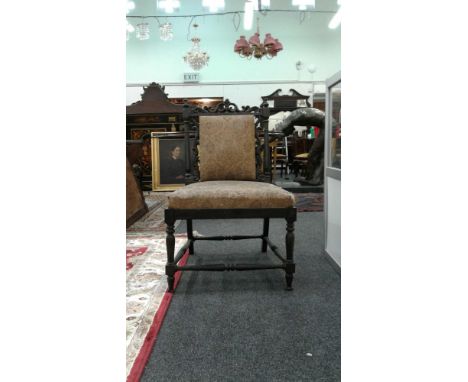 the carved back with upholstered centre panel raised above an upholstered drop in seat on turned supports with stretcher rail